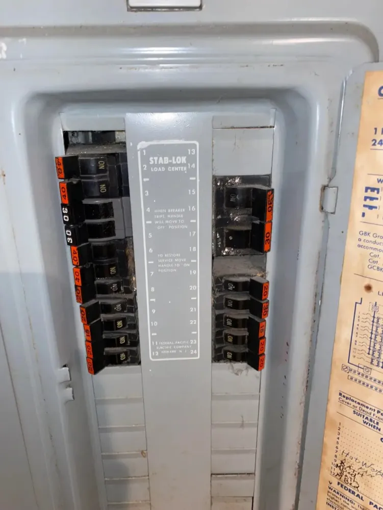 Federal Pacific Stab-Lok electrical panel with black breakers and orange amperage labels.